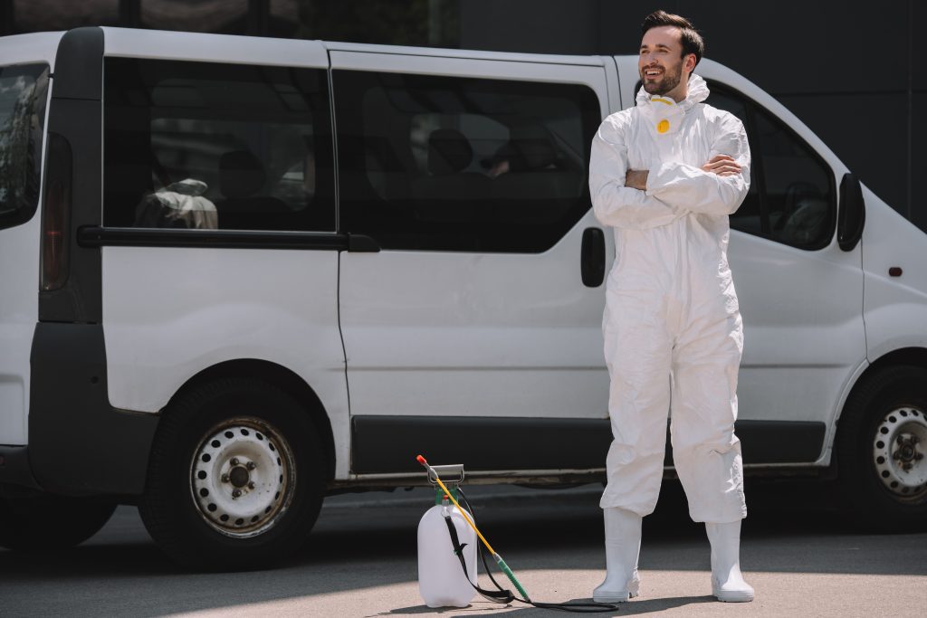 Reliant Pest Control technician in uniform beside service vehicle